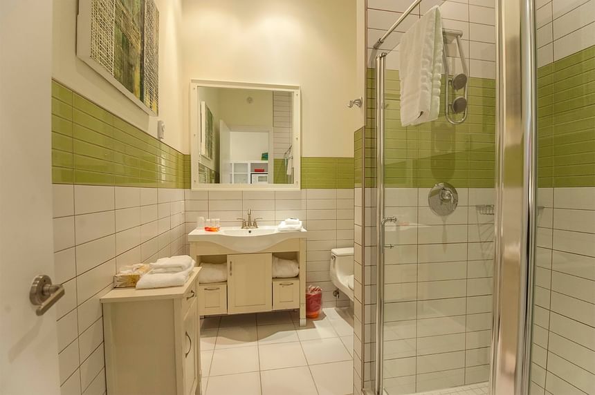 bathroom with green and white tiled glass walk in shower 