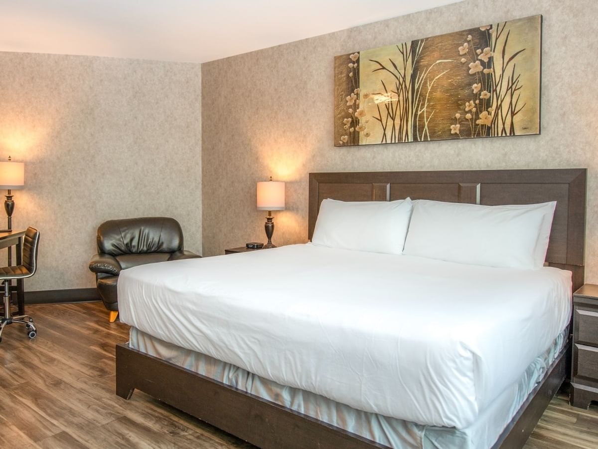 Coast King room with a large bed, two lamps, a desk, and a painting on the wall at Coast Lonsdale Quay Hotel