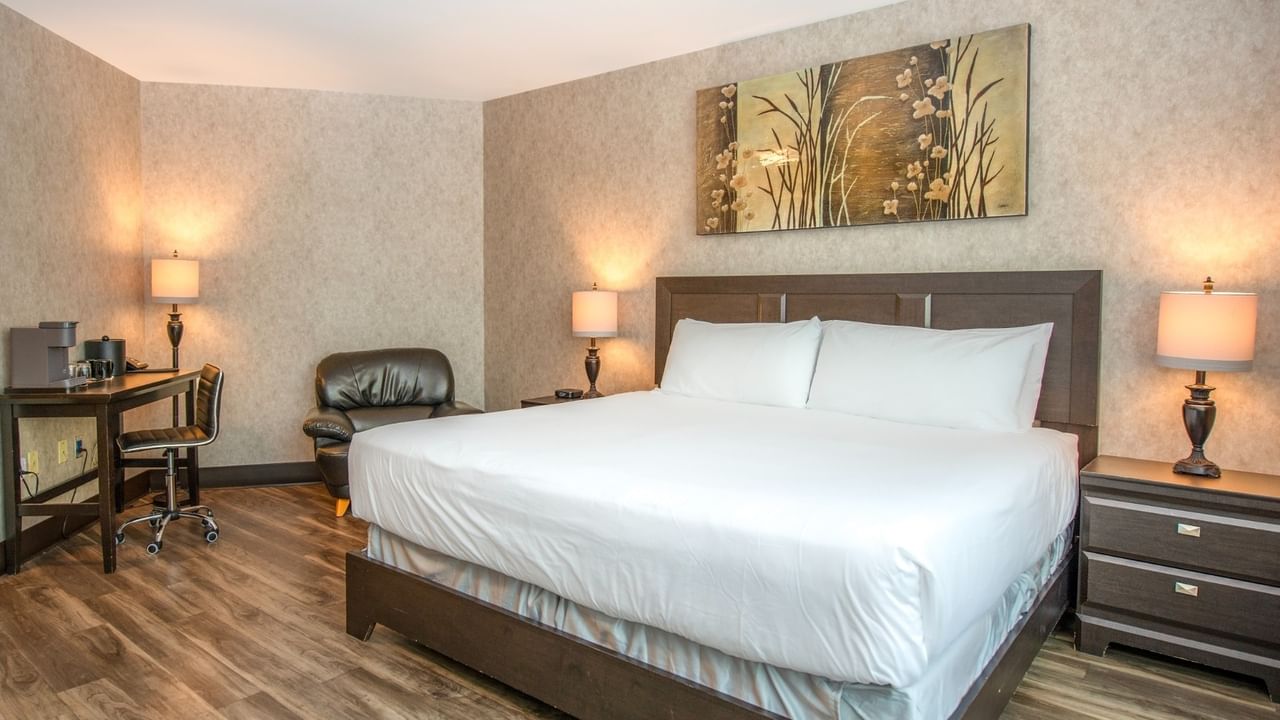 Coast King room with a large bed, two lamps, a desk, and a painting on the wall at Coast Lonsdale Quay Hotel