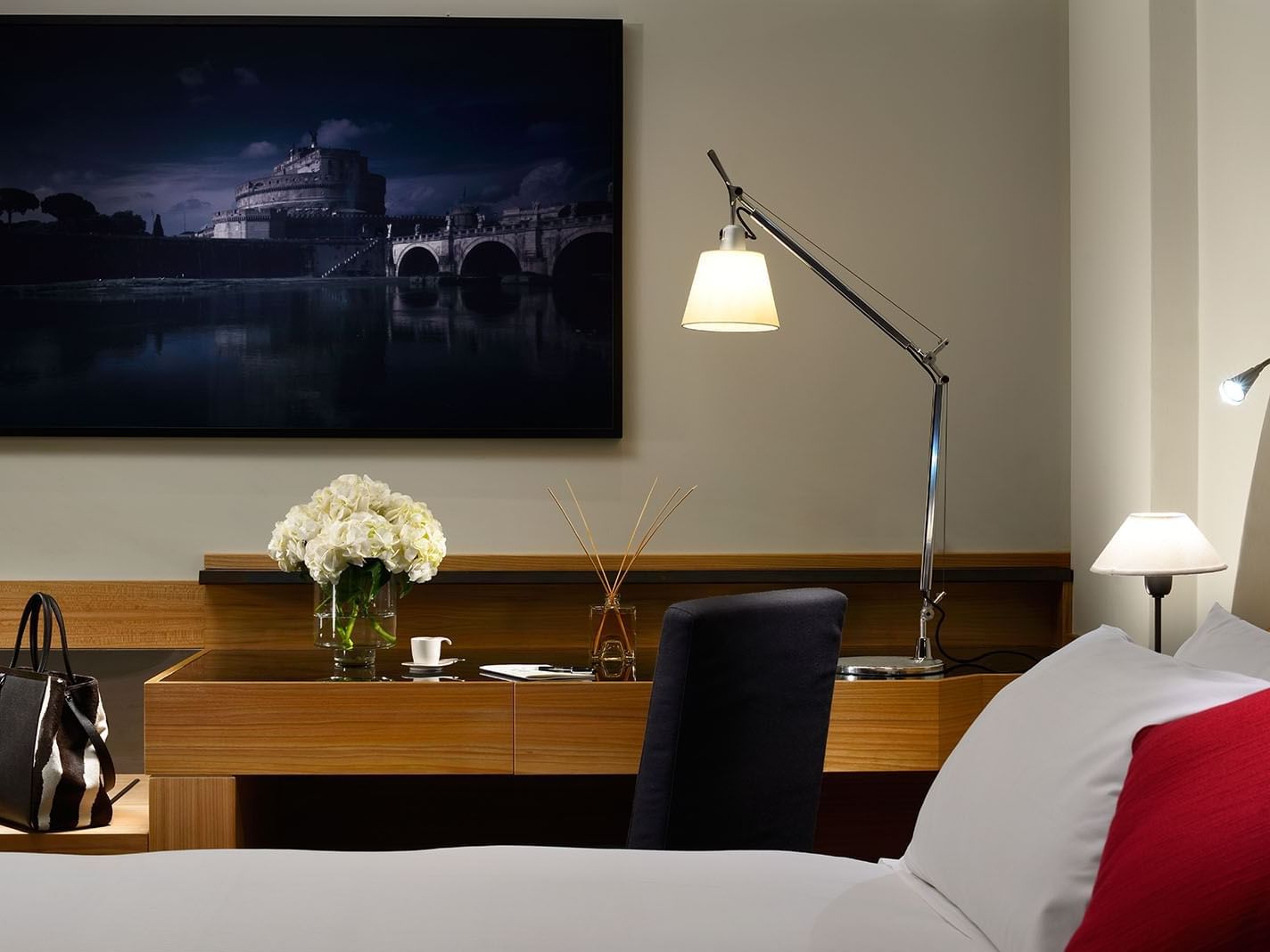 Work desk with a lamp by a cozy bed in Junior Suite at Margutta 54