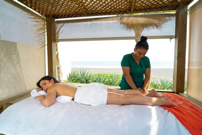 A lady receiving a massage by a masseuse at La Mar Monterrico