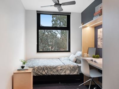 La Trobe University - North and South Apartments bedroom with bed, desk, and window.