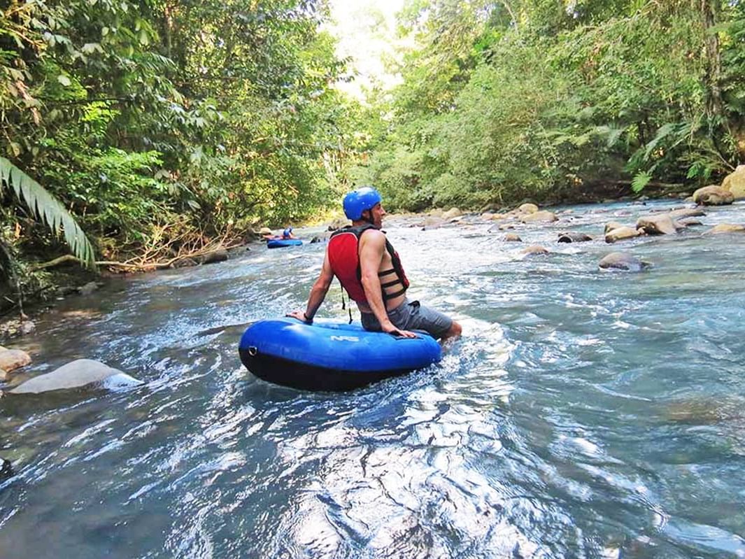 A man white water tubing near Rio Celeste Hideaway