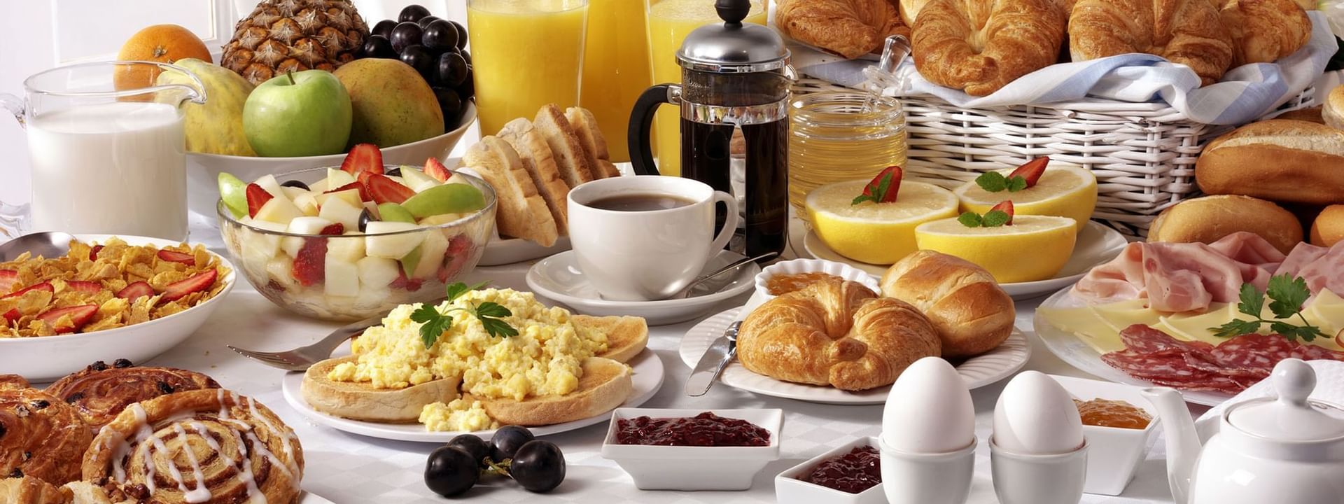 Abundant breakfast buffet with eggs, fresh fruit, and pastries served by a French press at Hotel Westminster Paris