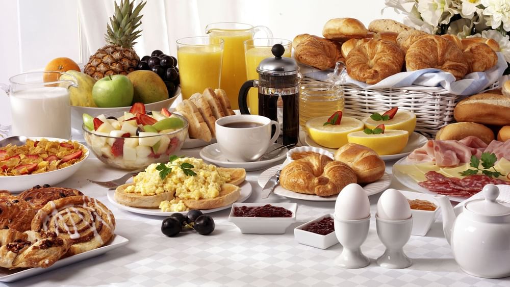 Abundant breakfast buffet with eggs, fresh fruit, and pastries served by a French press at Hotel Westminster Paris