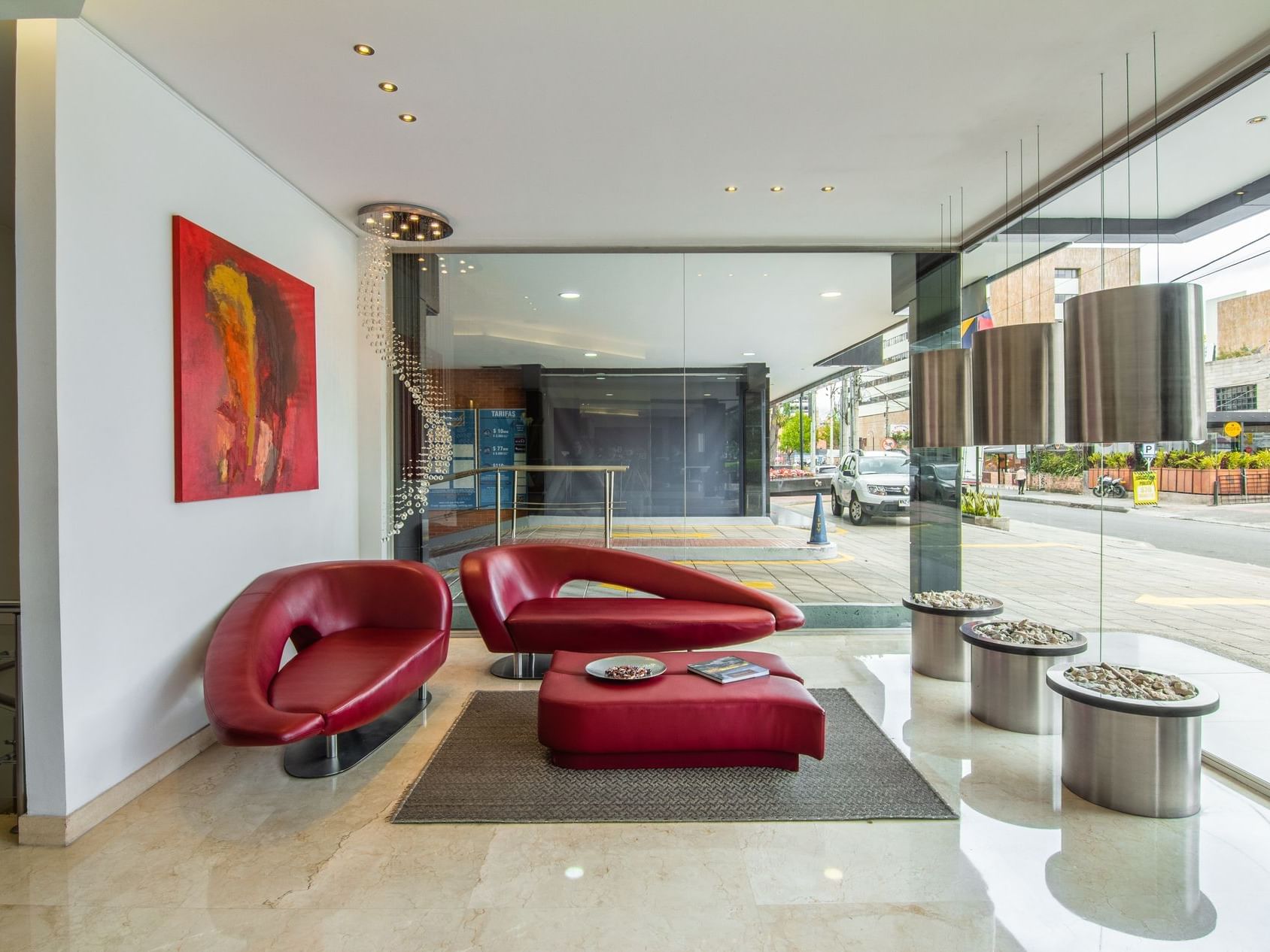 The lobby area with red couches, a coffee table and a fireplace