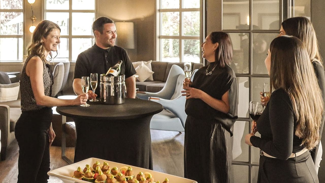 A team enjoys champagne and hors d'oeuvres during the welcome happy hour of their corporate retreat in Canmore.