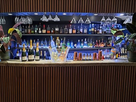 Bar counter with cocktails, champagne, and liquor in Bonobo’s Bar at Splendid Hotel & Spa Nice