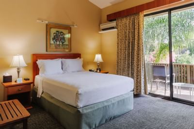 Large bed & balcony in Garden Room at Dinah's Garden Hotel