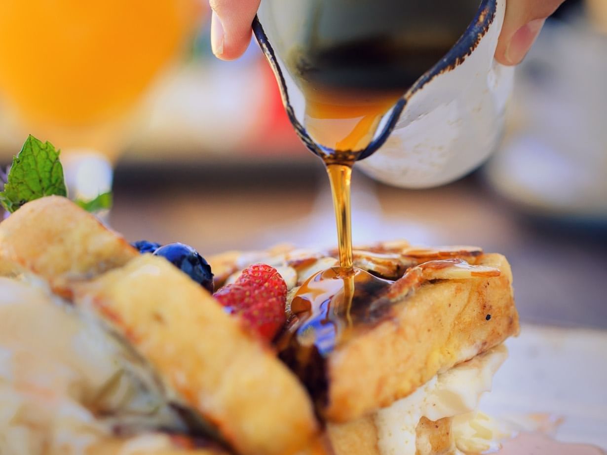 Syrup being poured over french toast