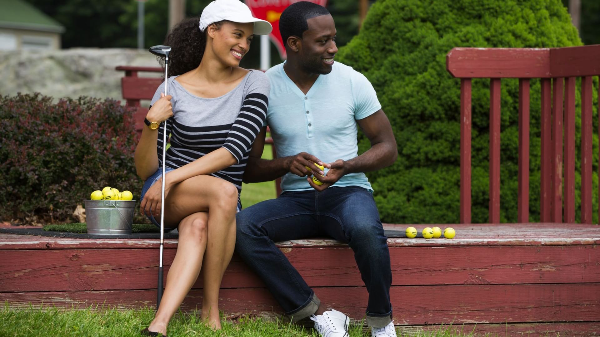 Couple sitting on a deck getting ready to play Miniature Golf at Cove Pocono Resorts