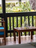 Two wooden chairs and side table with drink on balcony of Garden Bungalow at Warwick Le Lagon Vanuatu Efate.