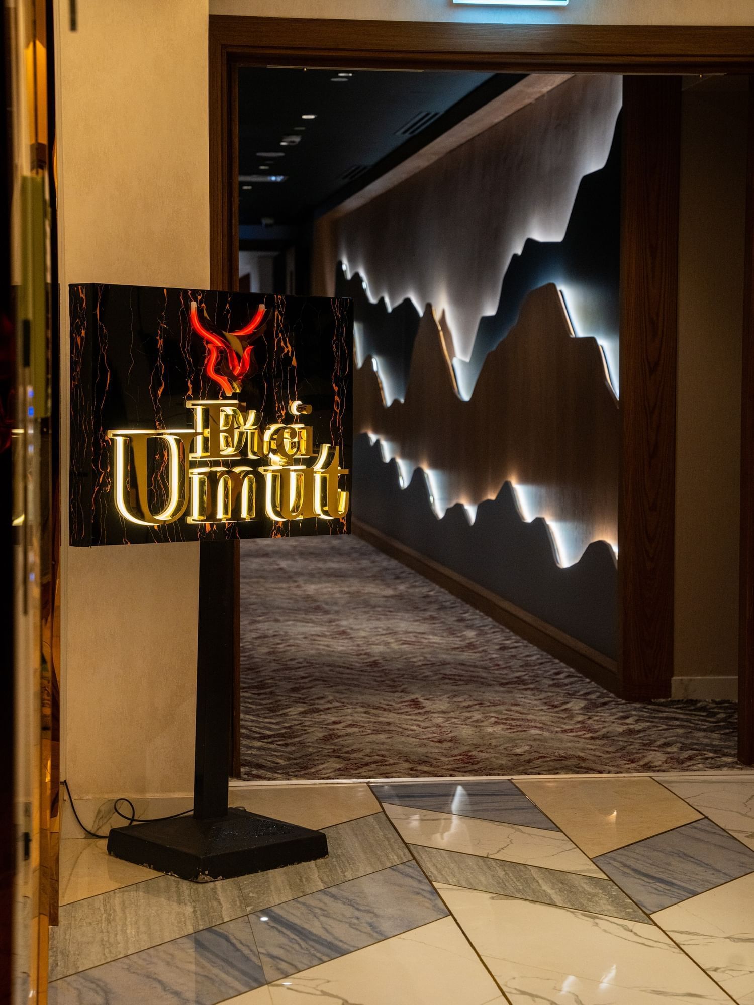 Illuminated Etçi Umut restaurant sign with warm wall lighting leading into elegant dining space near DAMAC Maison Aykon City