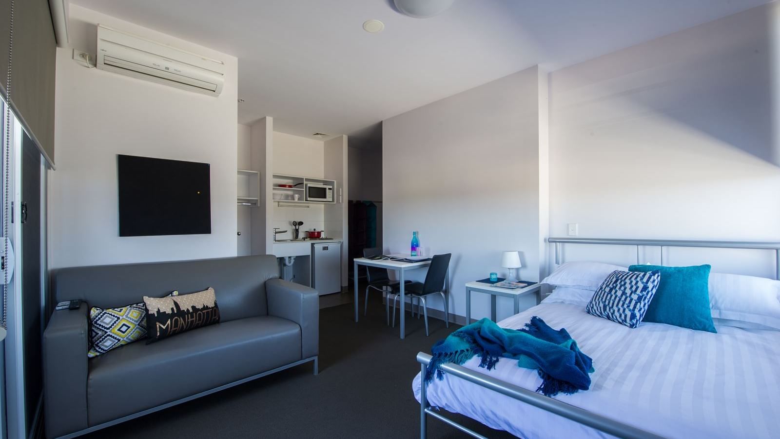 Typical studio double apartment featuring double bed, TV, study desk & chair, bedside table, dining table & chairs, 2 seat lounge, kitchenette & bathroom (not shown) - purchase hotel quality linen via our online shop, Your Shop