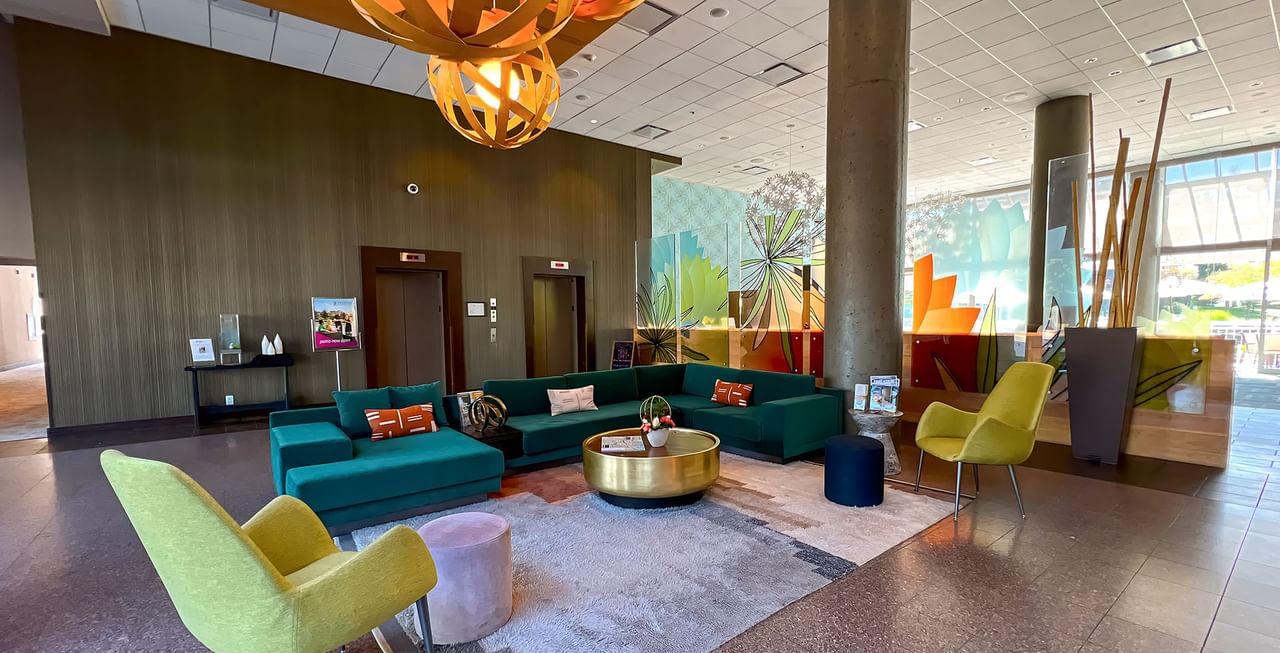 Lobby of hotel with couches, elevators, and tables