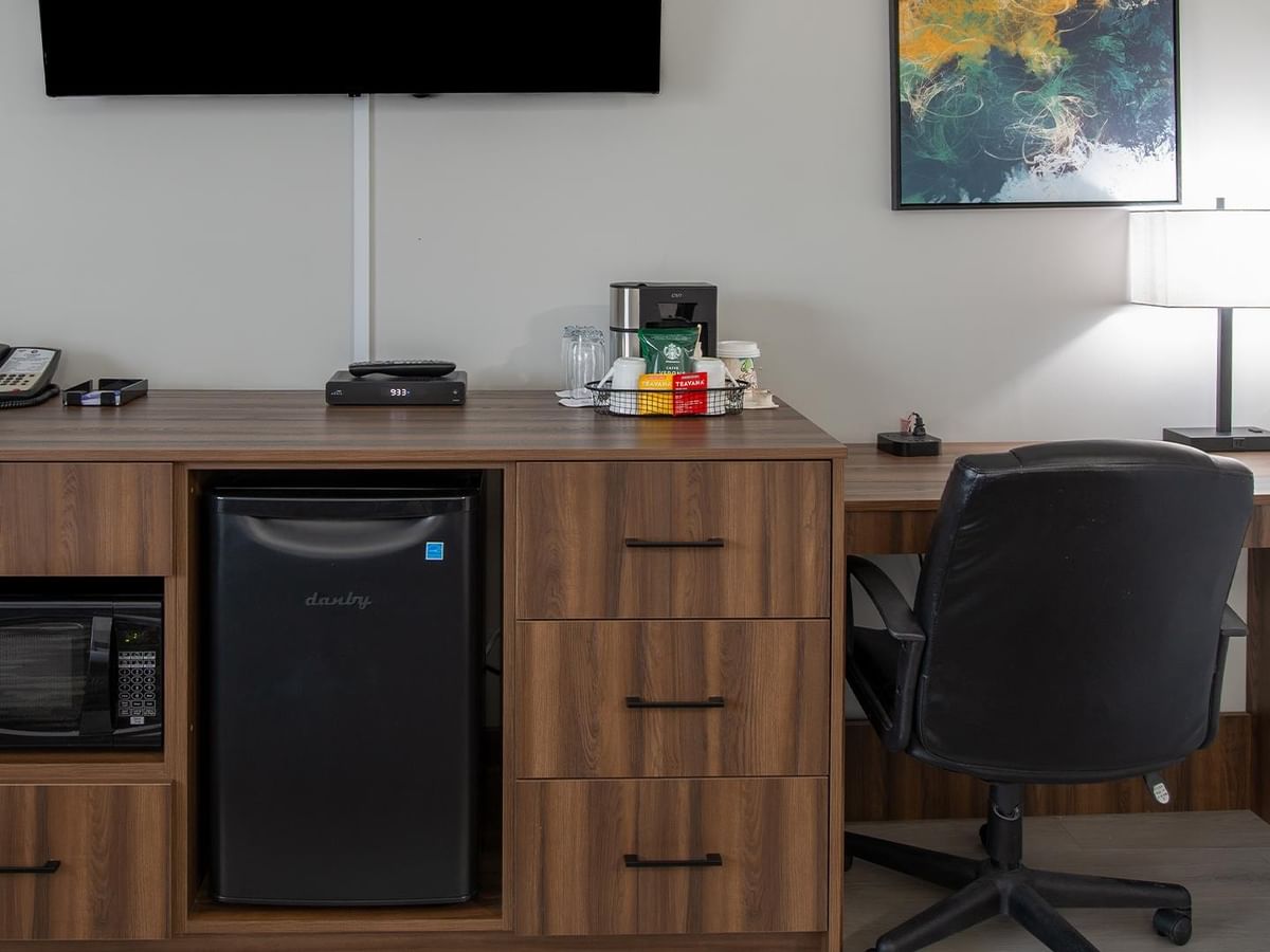 Desk with microwave, mini-fridge, and chair in Coast Two Queens room at Coast Dawson Creek Hotel.