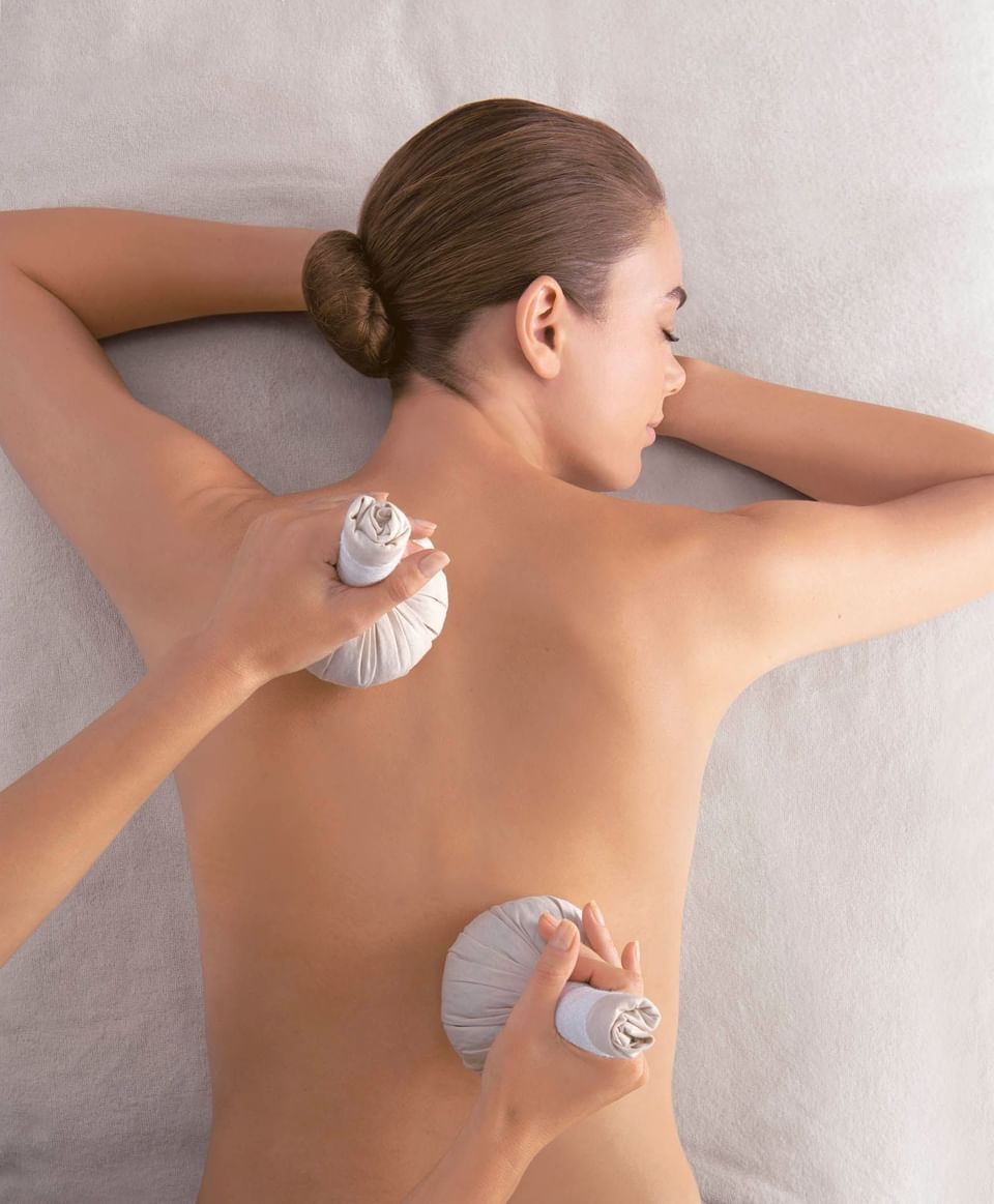 Woman receives a relaxing herbal compress massage at Thalgo Spa, The Saujana Hotel Kuala Lumpur