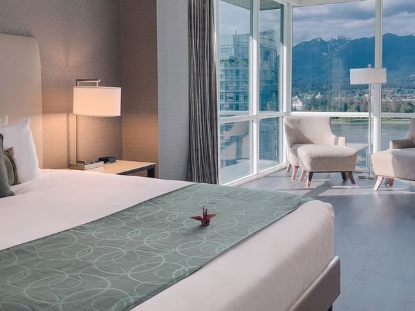 hotel room with king bed and lounge area with a view of harbour