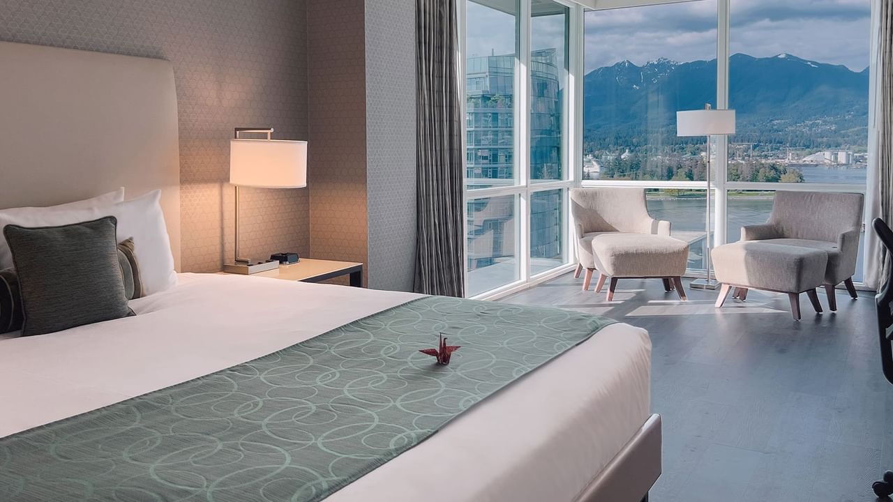 hotel room with king bed and lounge area with a view of harbour