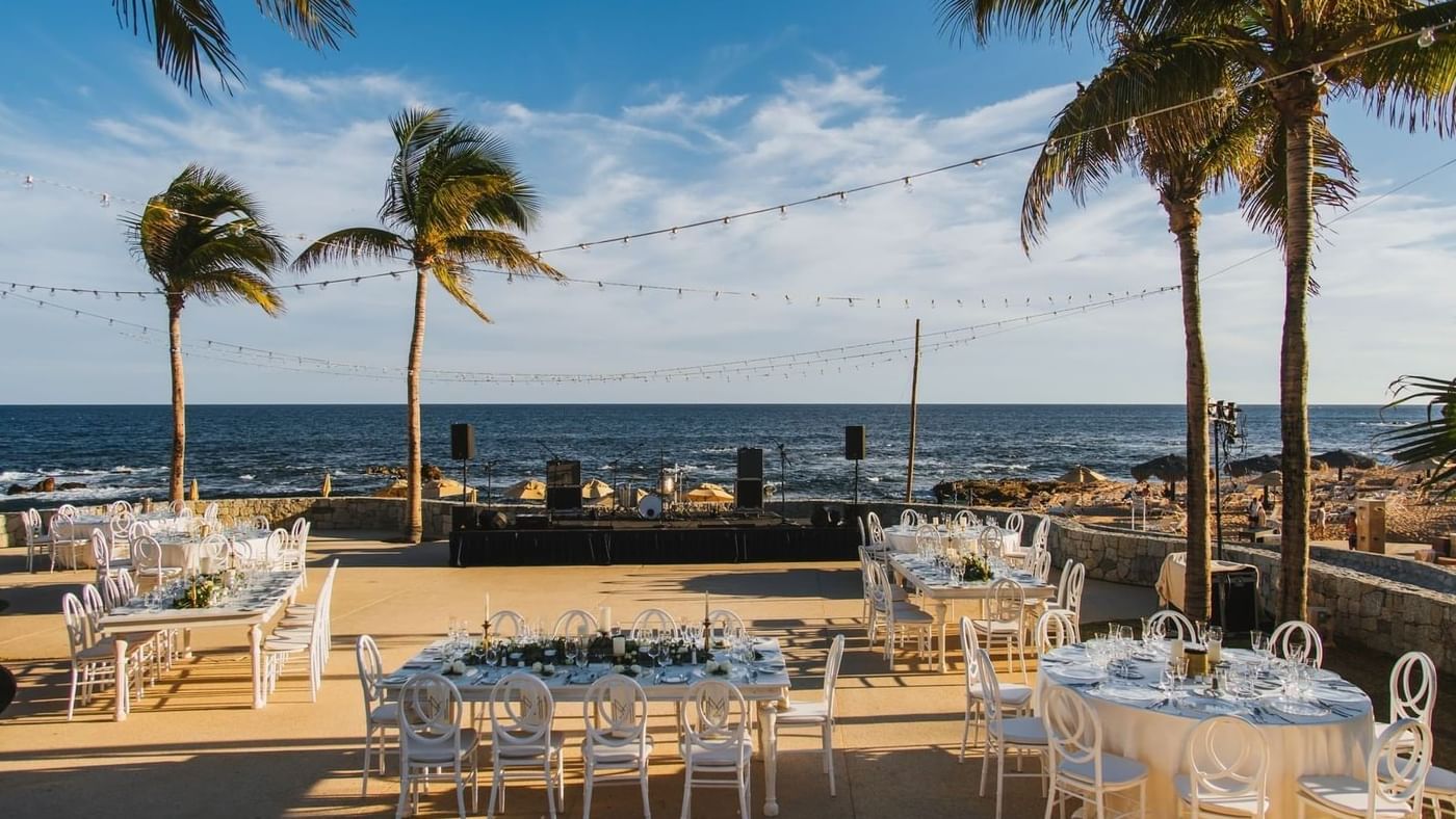 Outdoor event setup on the beach with tables, and chairs at Live Aqua Resorts