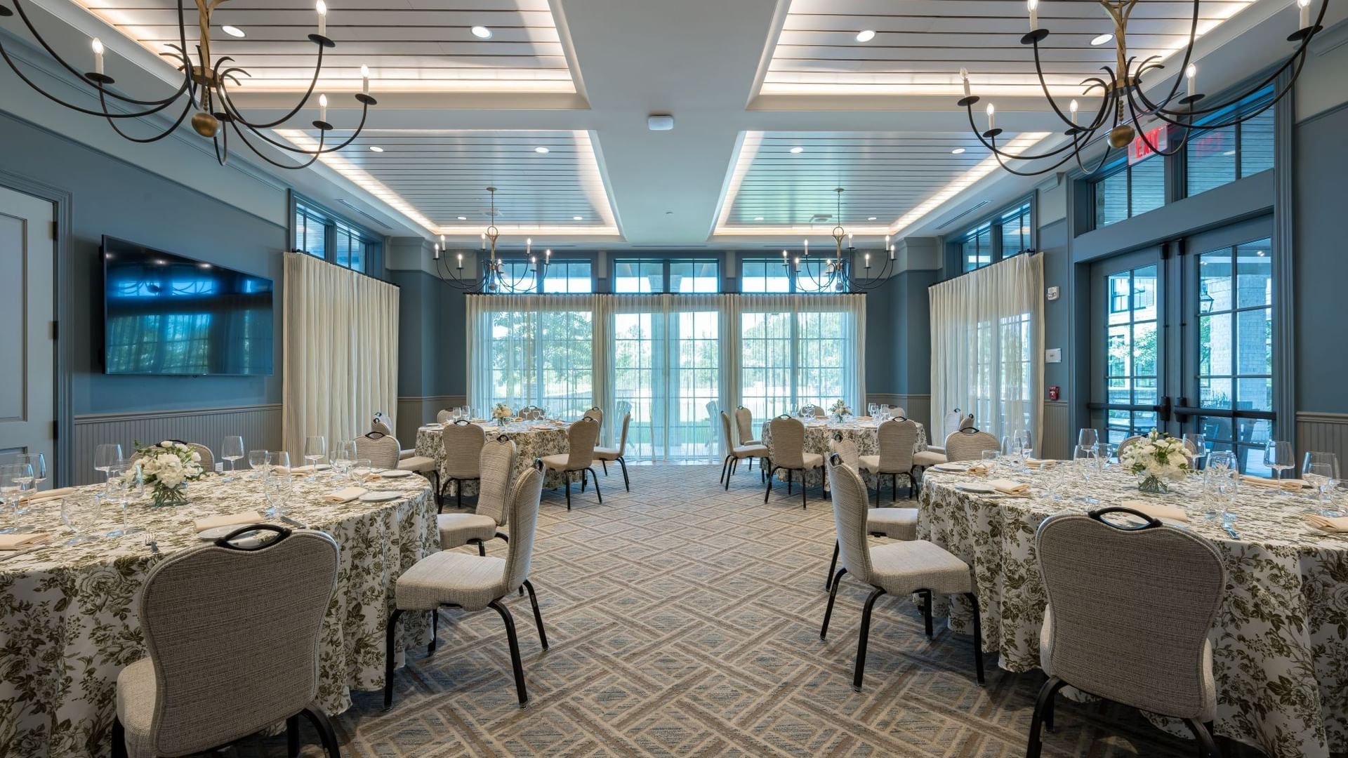 Elegant Club Room with floral-draped tables, upholstered chairs, and chandeliers at Camp Creek Inn in Inlet Beach.