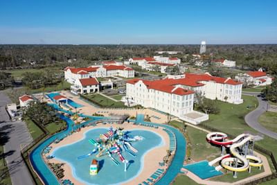 Aerial view of the complex showing red-roofed buildings, a large lazy river, and water slides at Centennial Plaza Resort