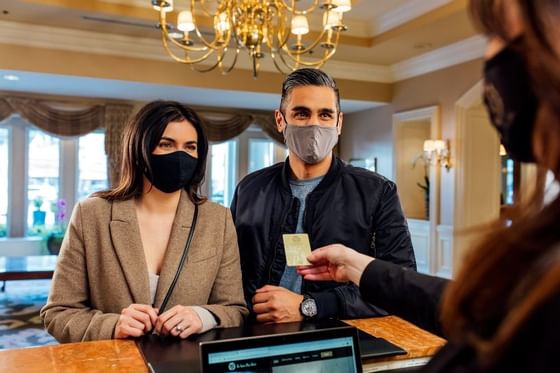 a couple checking into a downtown vancouver hotel wearing face masks