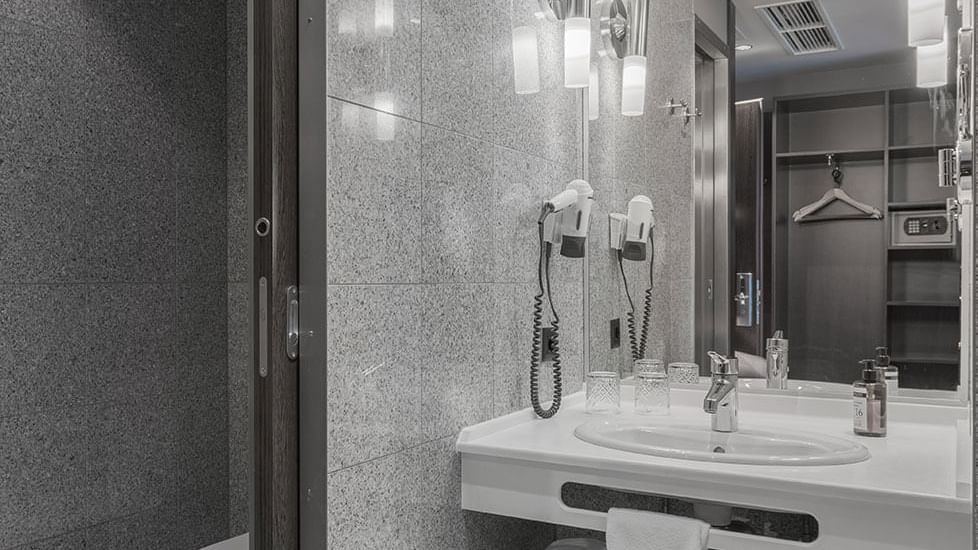 Waschtisch mit Waschbecken und Spiegel im Superior Zimmer im Titanic Comfort Kurfürstendamm