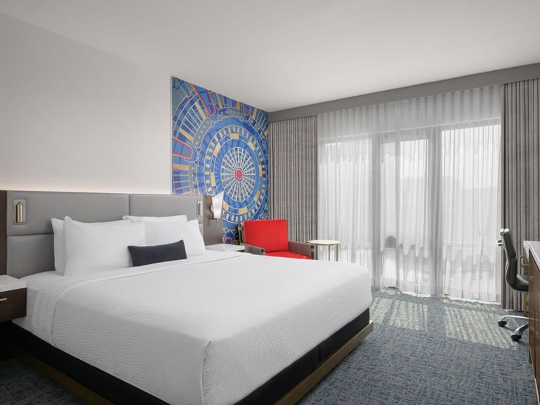 Boutique King with a mural of a cityscape on the wall and a red chair next to the bed at Hotel 43 Boise