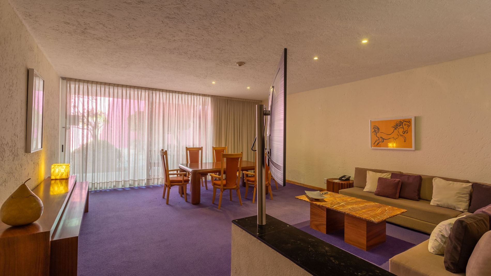 King Chapultepec Suite living area featuring purple floors, a dining set, and modern sofa at Camino Real Polanco Mexico