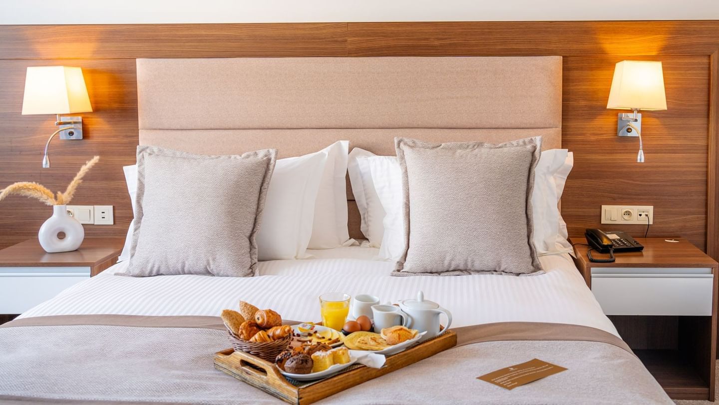 A hotel room bed with breakfast tray and pillows at Kenzi Basma