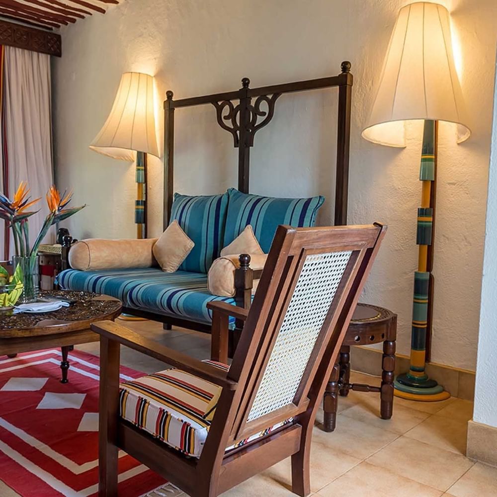 Elegant living space with wooden furniture and tropical decor in Lamu Suite at Serena Beach Resort & Spa Mombasa.