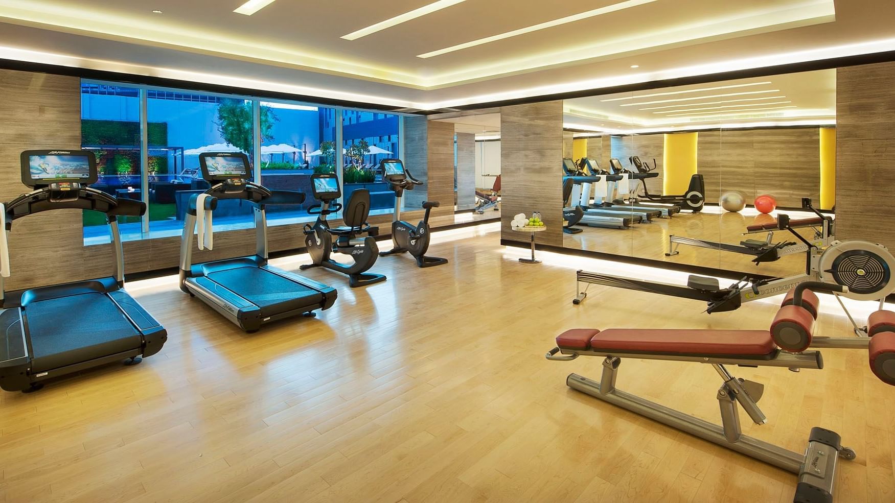 A fitness center with well-equipped machines and exercise equipment at DAMAC Maison Cour Jardin