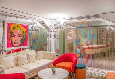 Vibrant lounge area in Hotel Éclat Beijing, featuring pop art decor and colorful seating.