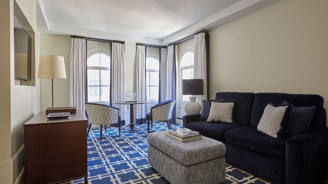 Dining table by the TV lounge area in Deluxe King Suite with geometric patterned carpet at El Prado Hotel