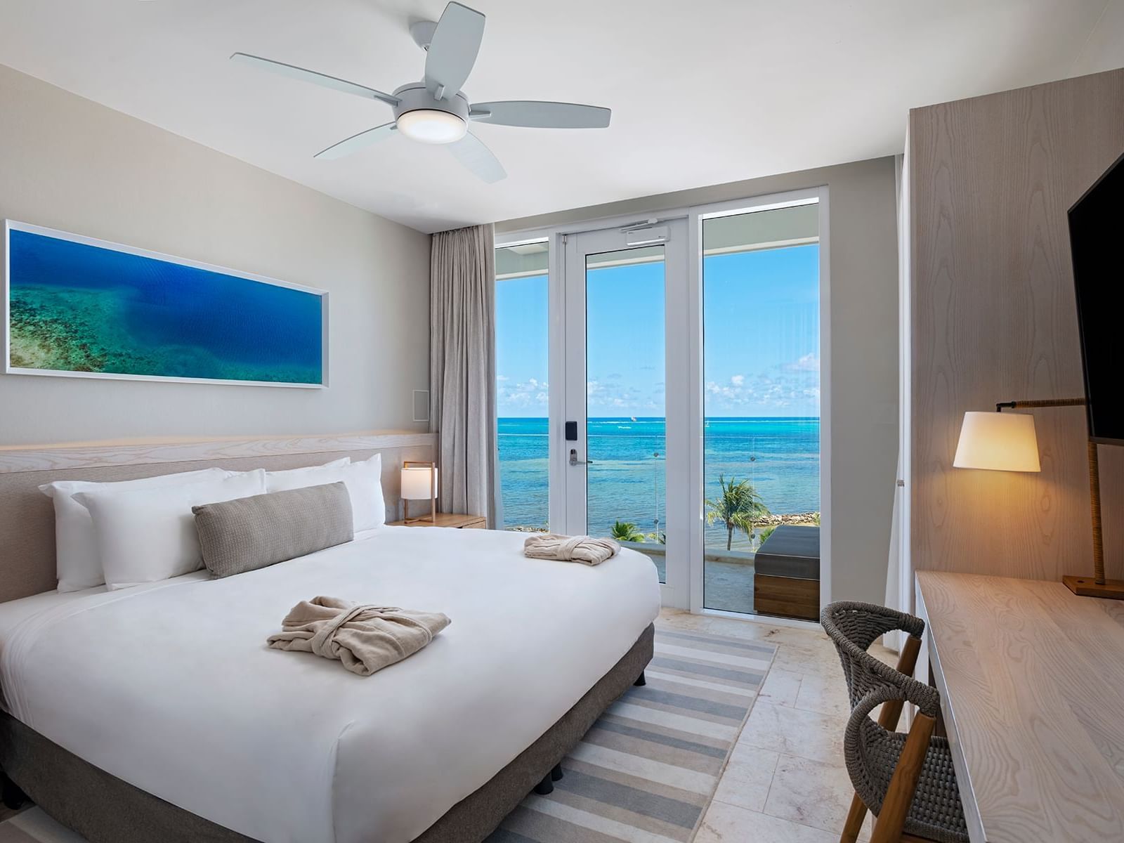 TV-facing king bed in Oceanview Vista Studio at Alaia Belize Autograph Collection
