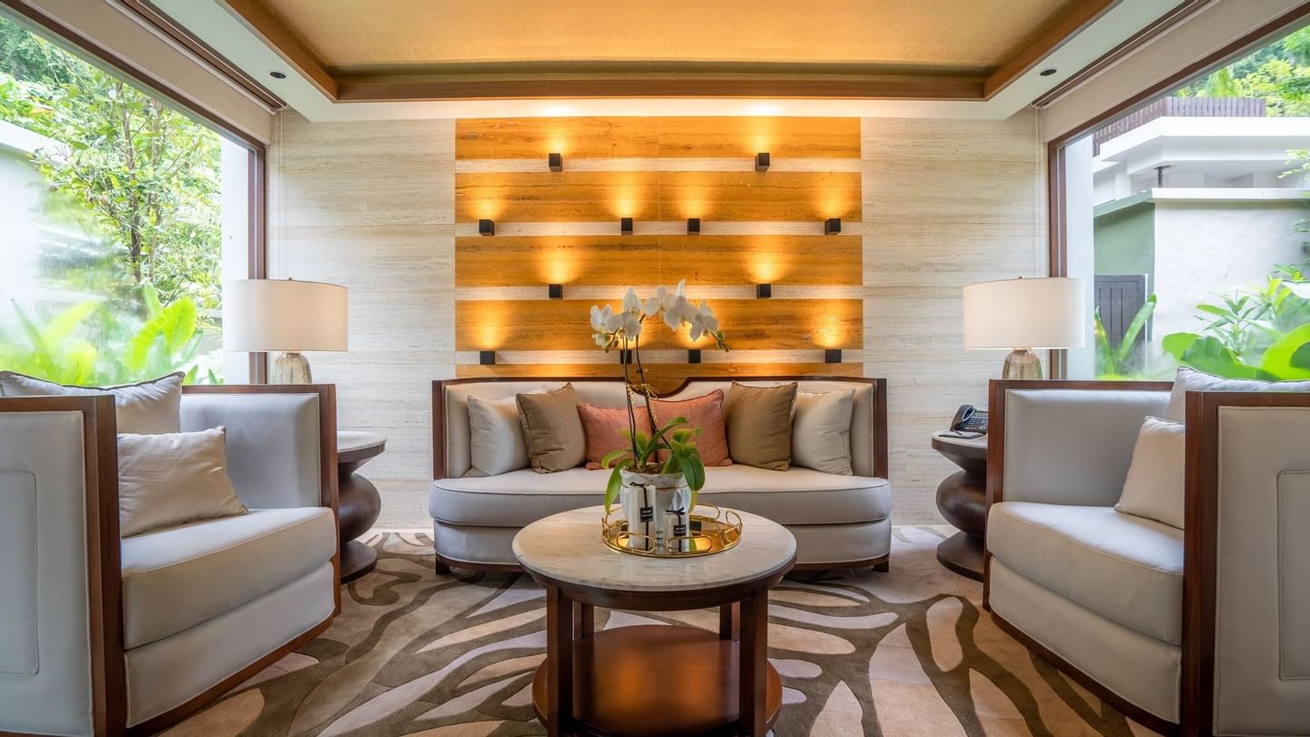 Royal Villa living area with modern seating, illuminated wood accent wall, and tropical garden views at The Banjaran.