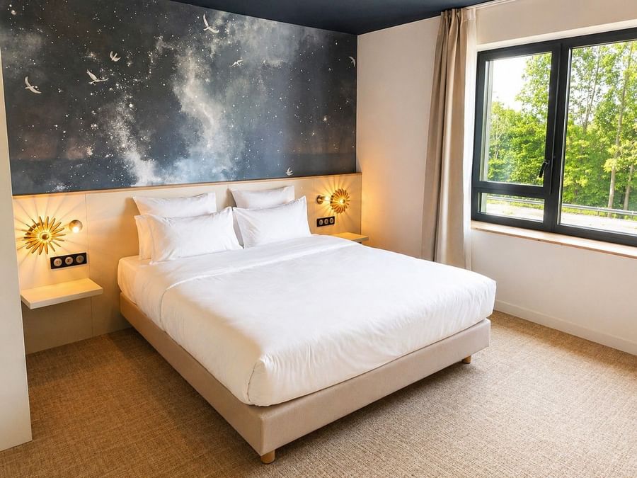 Chambre Junior Suite avec lit king-size et vue sur la forêt à Osmo Hôtel Chantepie.