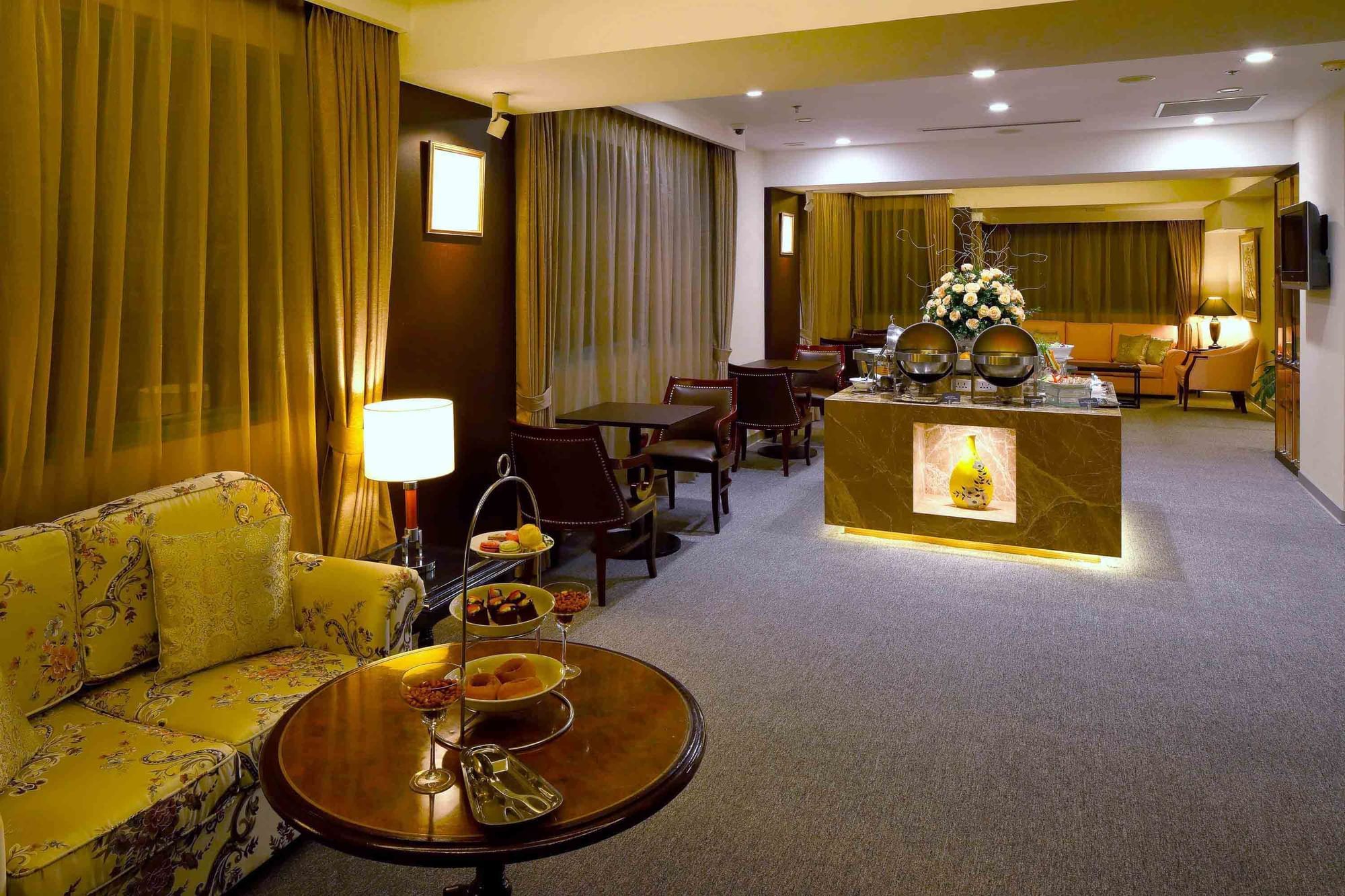Elegant lounge area with sofa, chairs and buffet setup at Sunway Hotel Hanoi
