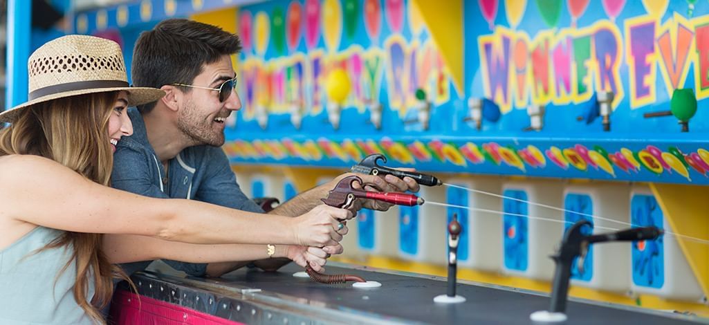 couple playing a watter shooting game at an amusement park