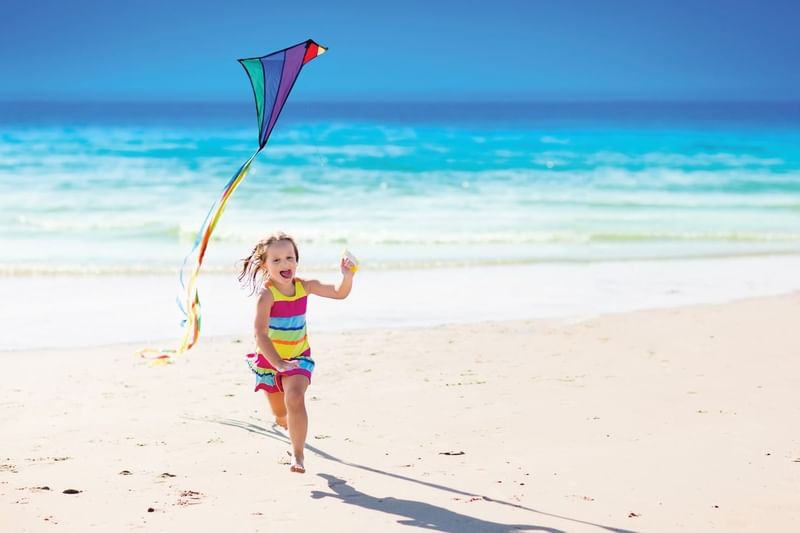 Small girl holding a kite on the Beach at The Diplomat Resort