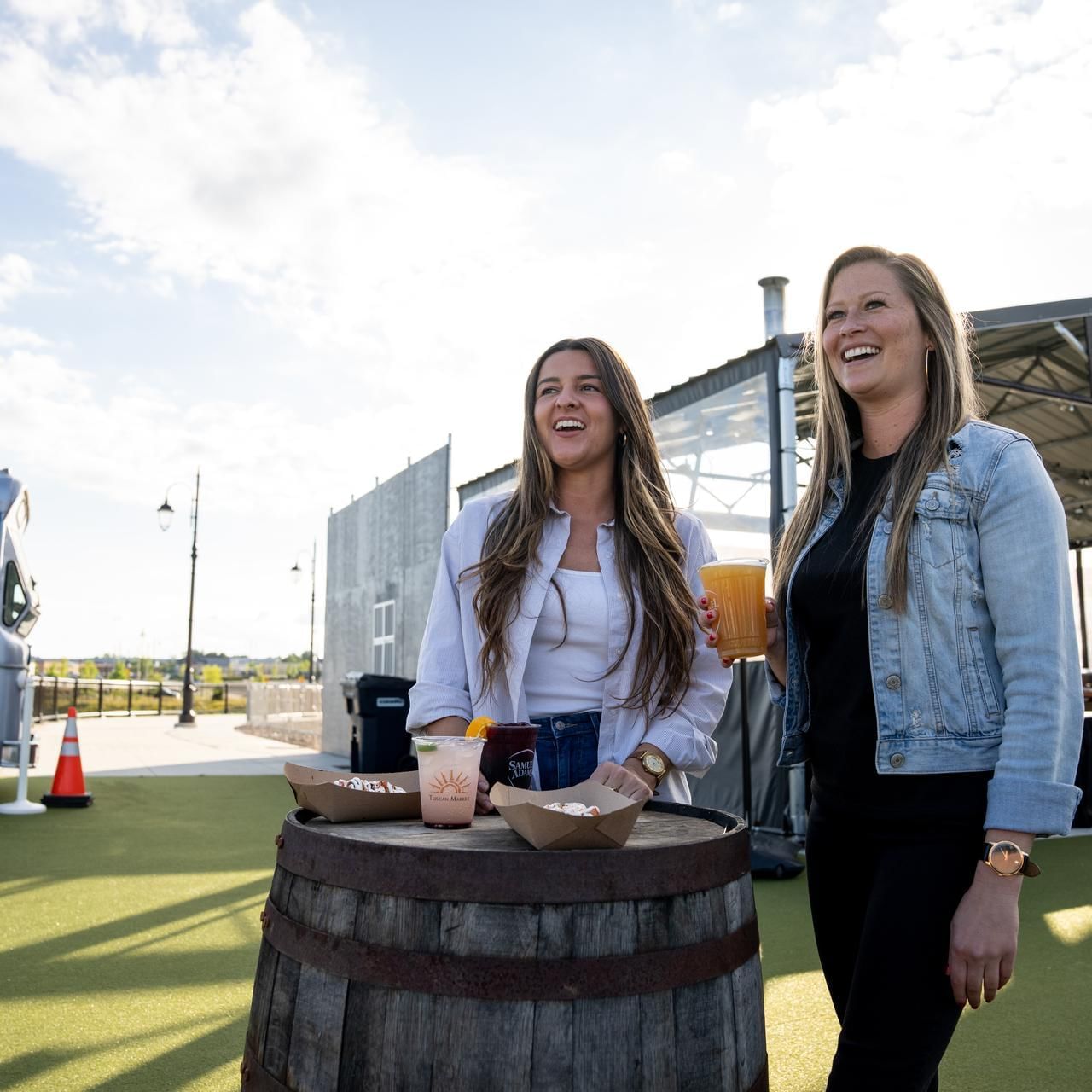 Two ladies with food & drinks in Beer Garden at The Artisan Hotel at Tuscan Village