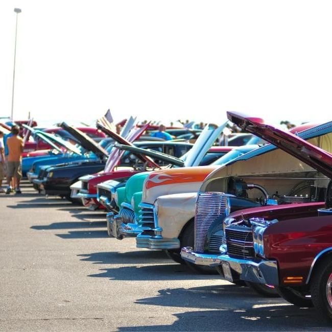 Vintage cars parked in rows with hoods up at the Wokingham Classic Motor Show.
