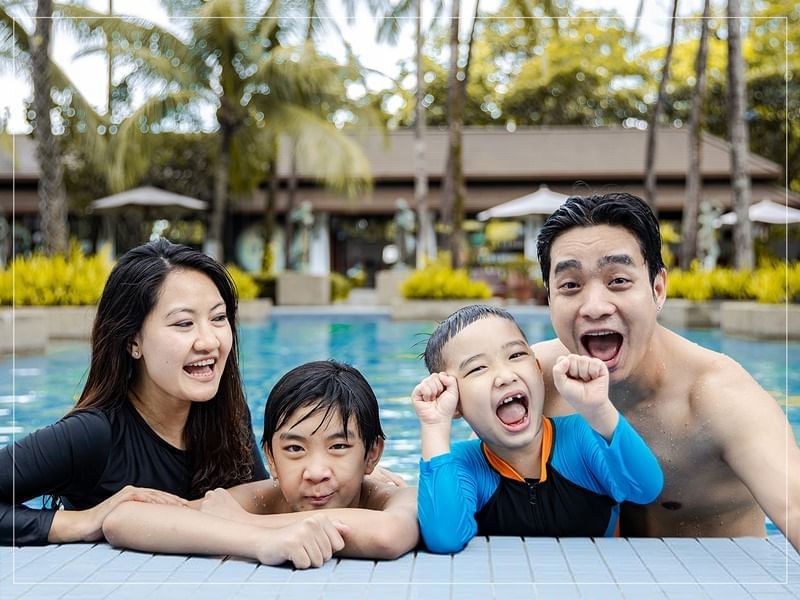 A family posing in the pool at Chatrium Royal Lake Yangon