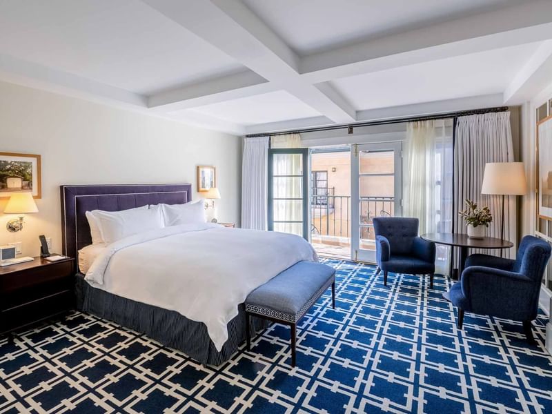 Elegant bedroom at El Prado Hotel, showcasing the VIP Pet Package with a spacious bed and modern decor