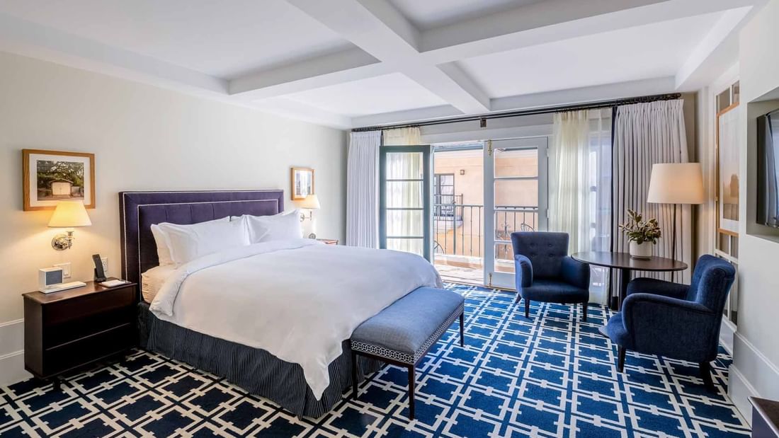 Elegant bedroom at El Prado Hotel, showcasing the VIP Pet Package with a spacious bed and modern decor