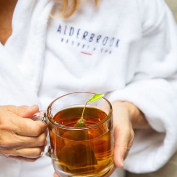 Close-up of hands holding a tea in the Spa at Alderbrook Resort & Spa