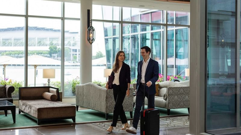 Couple heading to the concierge to drop off their luggage
