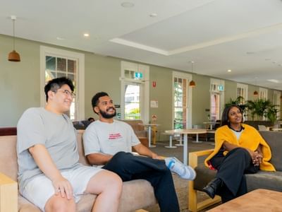Students relaxing on couches in lounge area at UniLodge Herston.