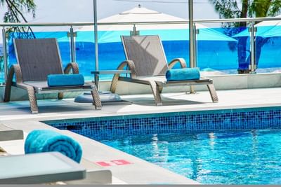 Lounge chairs by pool at Abidah Hotel, an all-inclusive adults-only hotel near Miami beach, Barbados offering relaxing escape